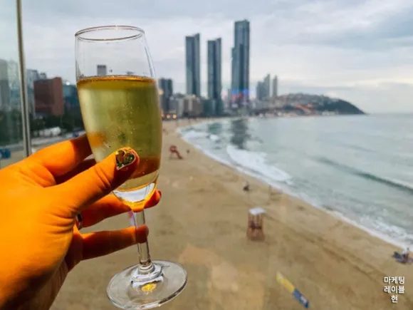 부산 바다를 바라보며 잔을 든 풍경